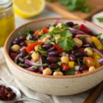 Dense bean salad recipe with chickpeas, black beans, and fresh vegetables