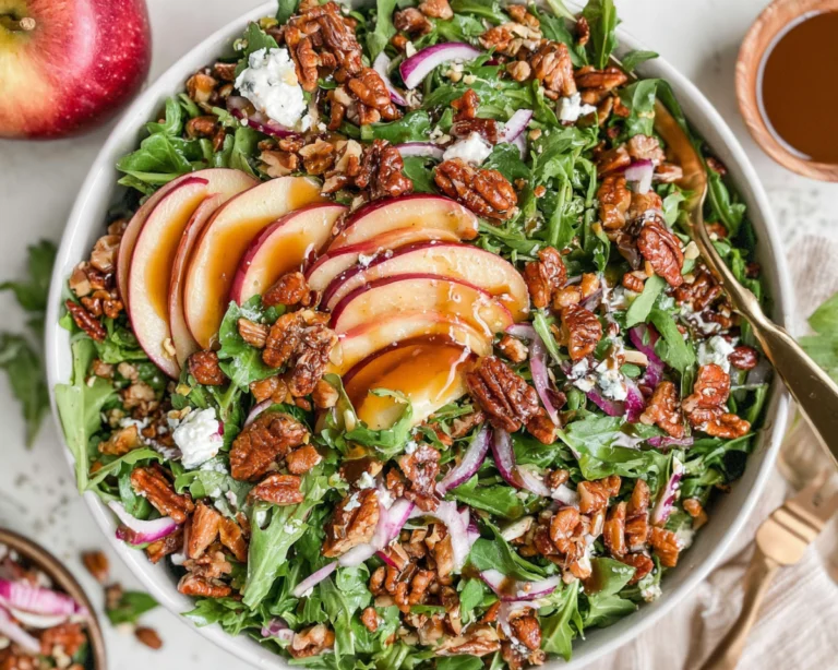 Apple arugula salad with sliced apples, maple pecans, goat cheese, and red onion
