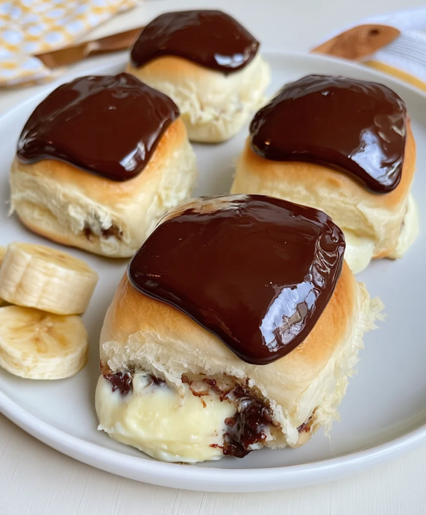 Soft Hawaiian rolls packed with creamy vanilla filling and topped with glossy chocolate ganache.